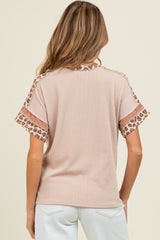 woman wearing a light brown maternity top with leopard print detail on the sleeves and back