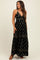 woman wearing a black floral maternity maxi dress with a v-neck and tiered skirt, showcasing her baby bump