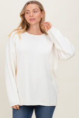 woman wearing a cozy white oversized sweater paired with denim jeans