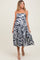 woman wearing a navy and white swirl print maternity dress with adjustable straps and a flowy tiered skirt