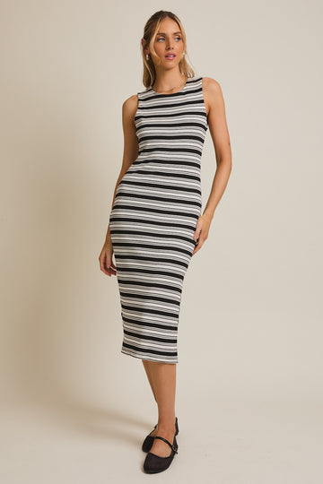 woman wearing a black and white striped midi dress with a fitted silhouette and sleeveless design