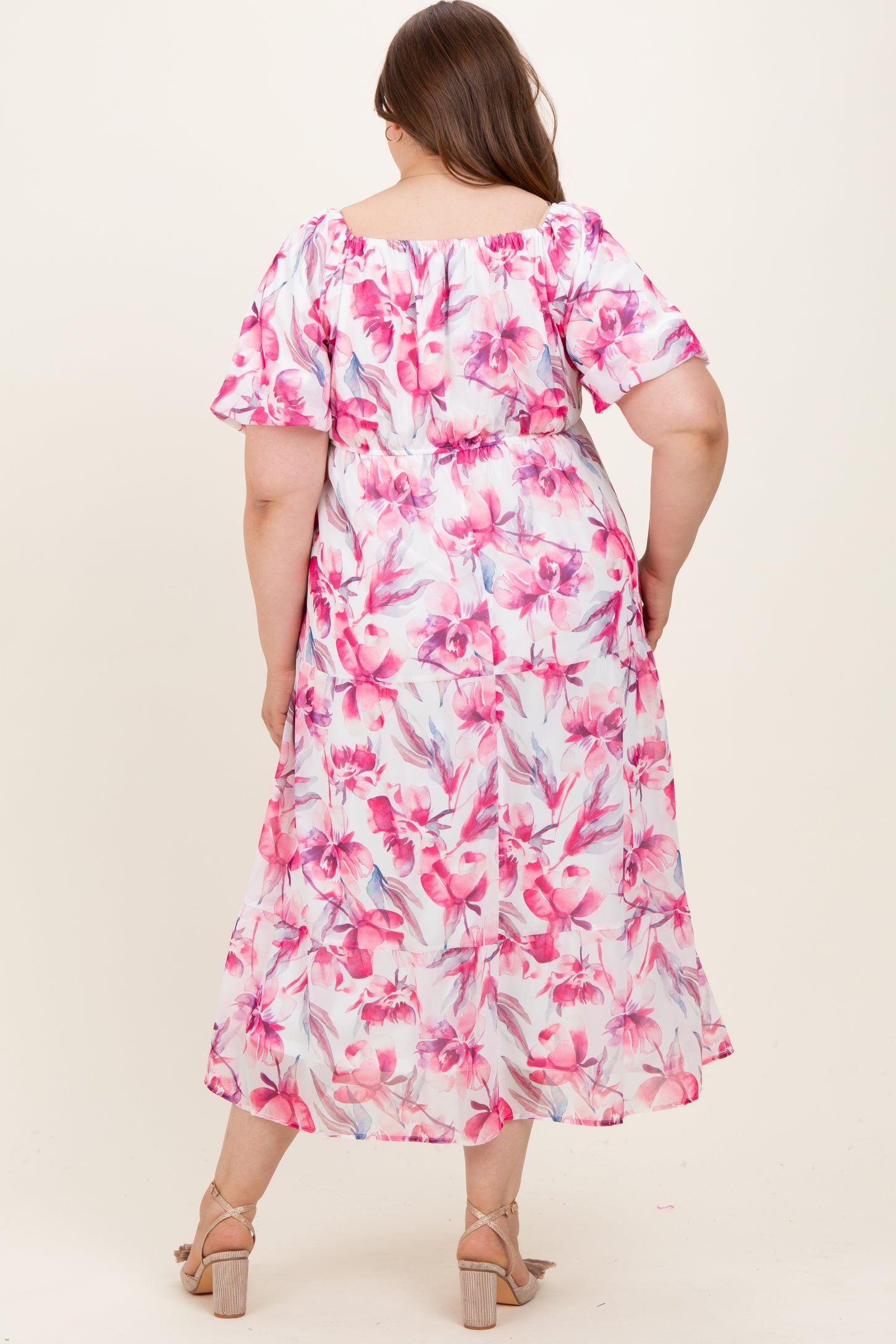woman wearing a floral maxi dress with short sleeves, showcasing a maternity plus style and relaxed fit from the back
