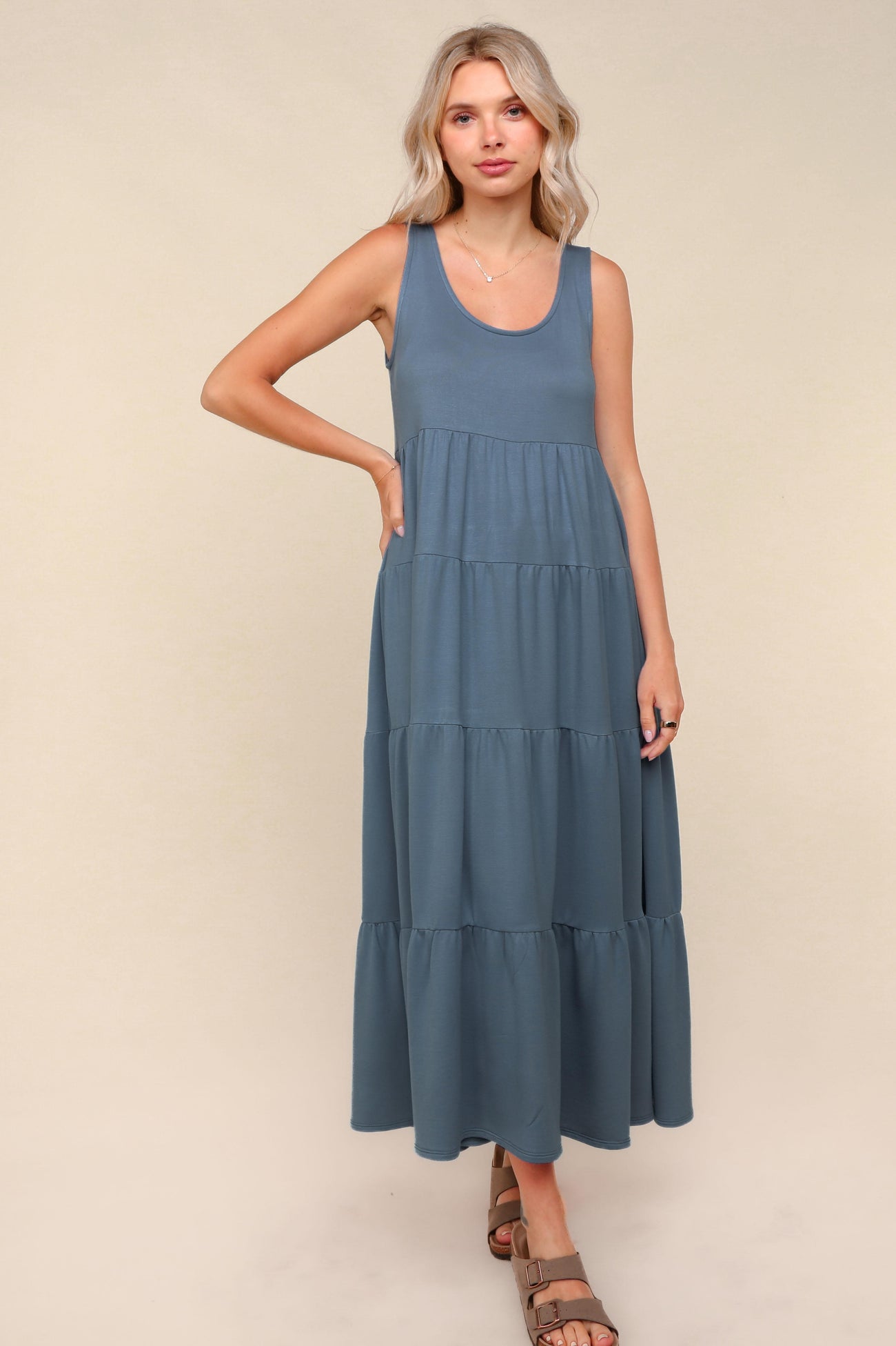 woman wearing a sleeveless blue maxi dress with tiered ruffles and a relaxed fit