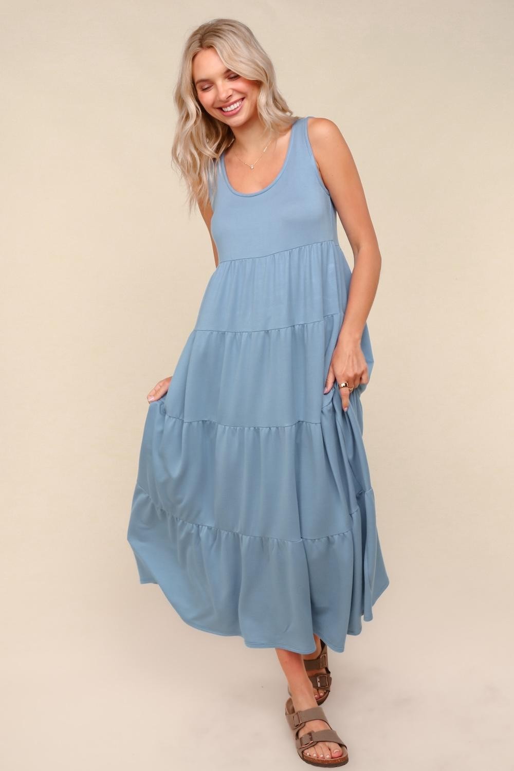 woman wearing a blue tiered maxi dress with a sleeveless design and a relaxed fit