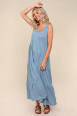 woman wearing a light blue tiered maxi dress with a scoop neckline and flowy silhouette