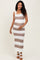 woman wearing a striped brown and white maternity dress, smiling and holding her baby bump