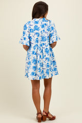 woman wearing a short-sleeve blue and white floral maternity dress, seen from the back