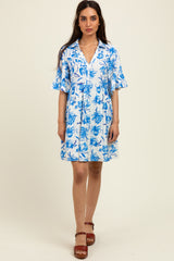 woman wearing a blue and white floral short sleeve collared dress with a fitted bodice and flared skirt