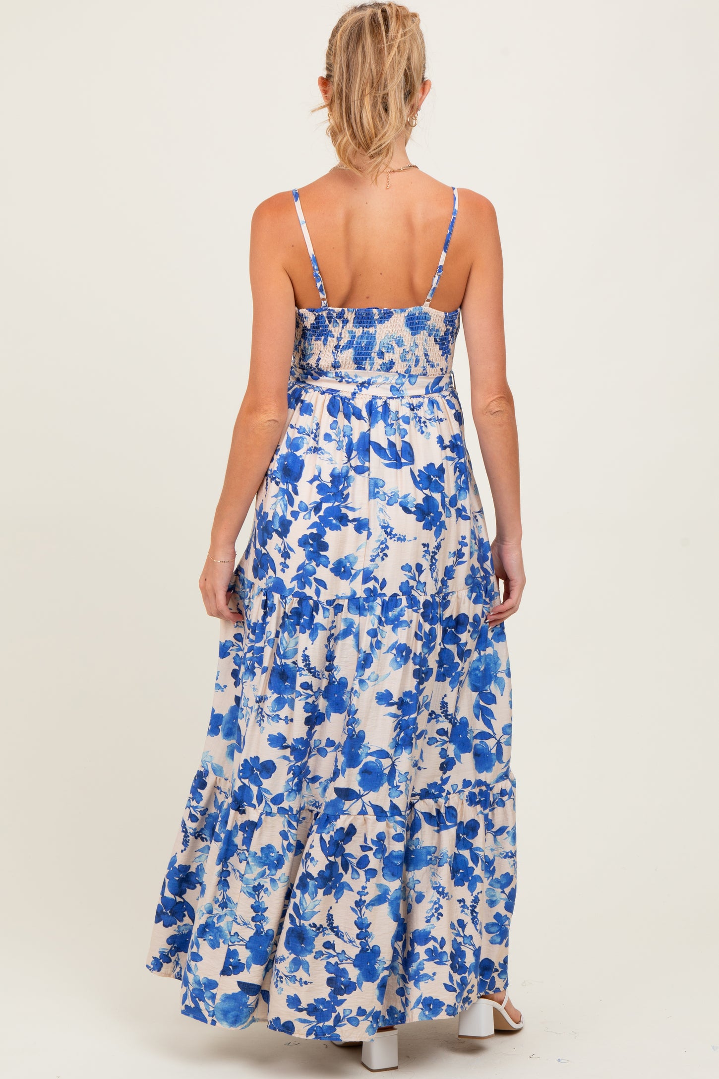 woman wearing a floral print maternity maxi dress with a smocked back and adjustable straps