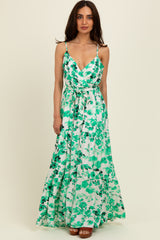 woman wearing a green floral maxi dress with spaghetti straps and a waist tie