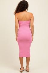 woman wearing a pink strapless midi maternity dress with a form-fitting silhouette and a slight slit at the hem