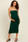 woman wearing a dark green strapless maternity dress and cradling her baby bump