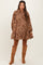 woman wearing a brown floral maternity dress with a tiered skirt and long sleeves, showing a baby bump