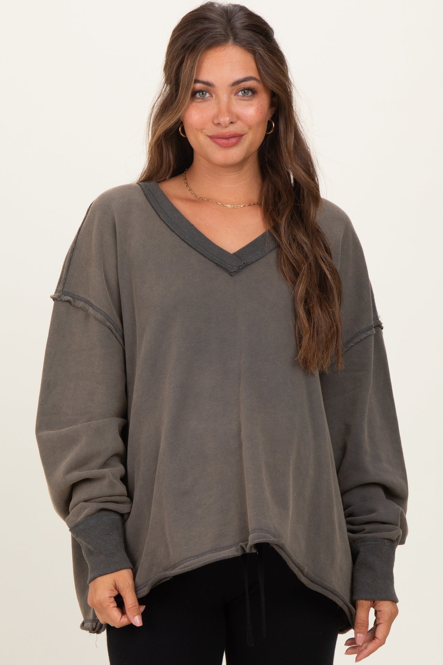 woman wearing a dark gray maternity sweatshirt with a v-neck and oversized fit