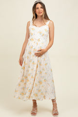 woman wearing a floral print maternity maxi dress with lace details and holding her baby bump