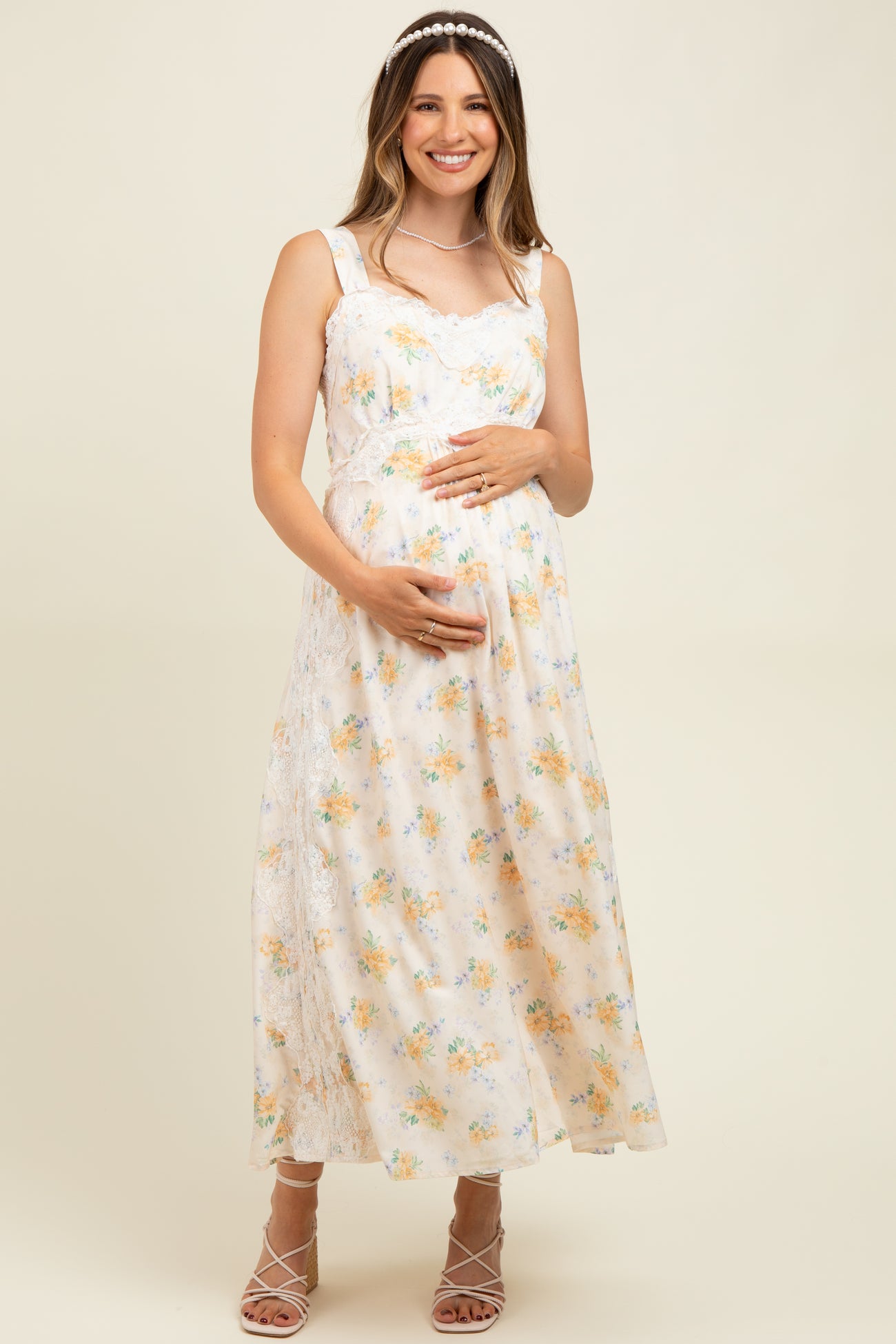 woman wearing a floral maternity maxi dress and holding her baby bump