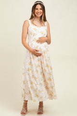 woman wearing a floral maternity maxi dress and holding her baby bump