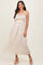 woman wearing a light pink floral maxi dress with spaghetti straps and ruffle details