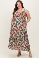 woman wearing a floral brown maternity plus maxi dress with pockets and adjustable straps, showcasing her baby bump