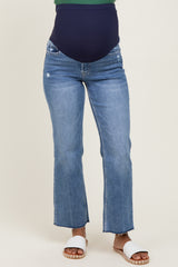 woman wearing blue maternity jeans with a dark band for support and frayed hem details