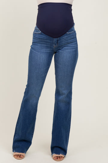 woman wearing blue maternity flared jeans with a navy belly band