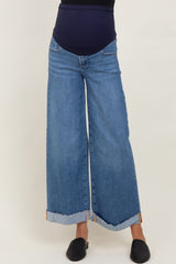 woman wearing maternity wide-leg denim jeans with a blue belly panel and cuffed hems