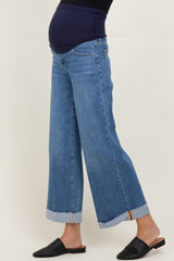 woman wearing maternity light wash wide leg jeans with a roll-up hem and a visible baby bump
