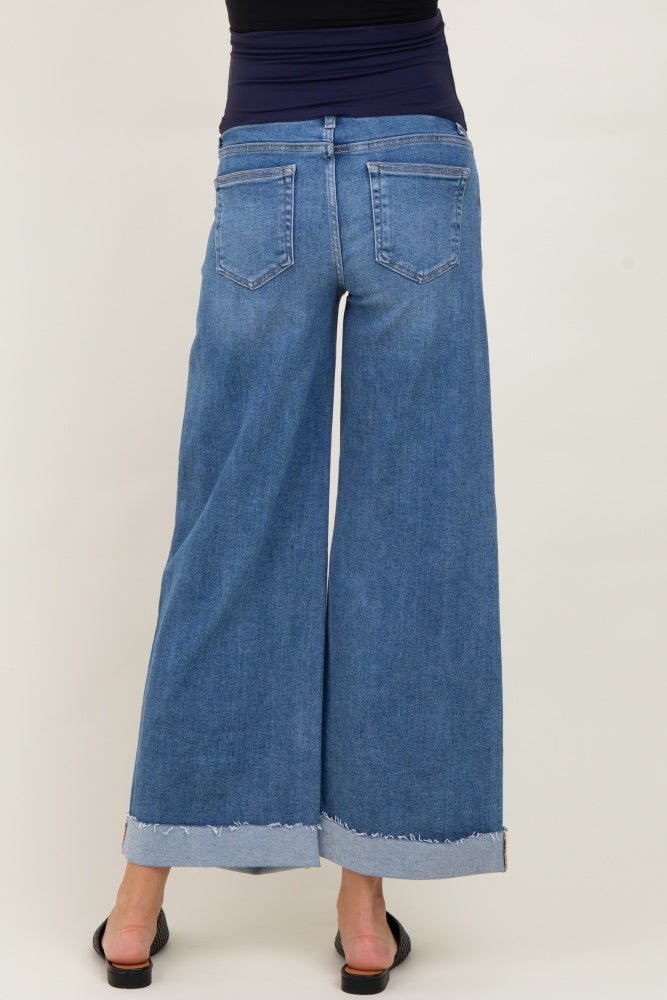 woman wearing a pair of wide-leg denim maternity jeans with a frayed hem and visible pockets