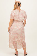 woman wearing a light pink floral maternity plus dress with a waist tie and flutter sleeves, viewed from the back