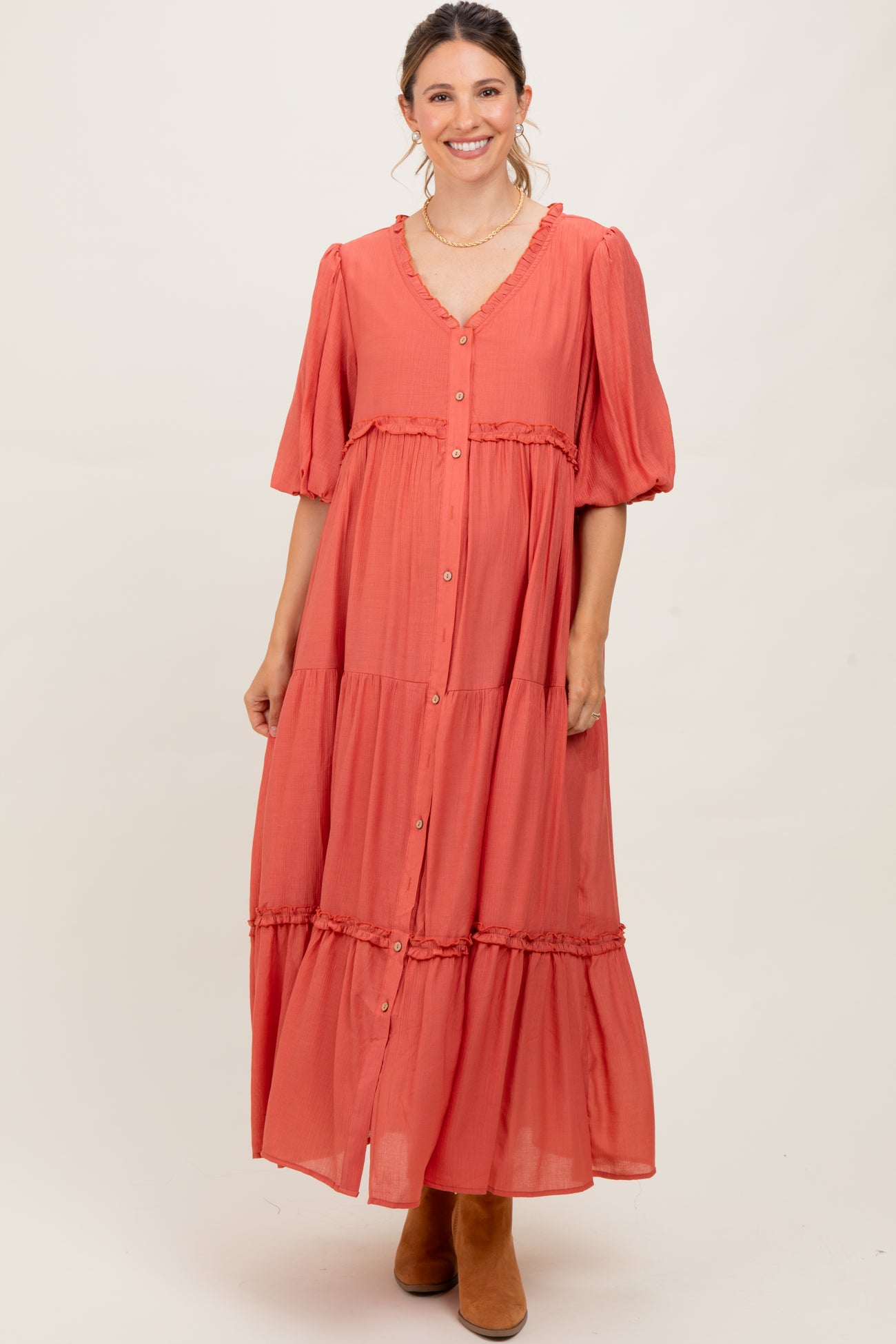woman wearing a coral maternity maxi dress with button details and short puff sleeves