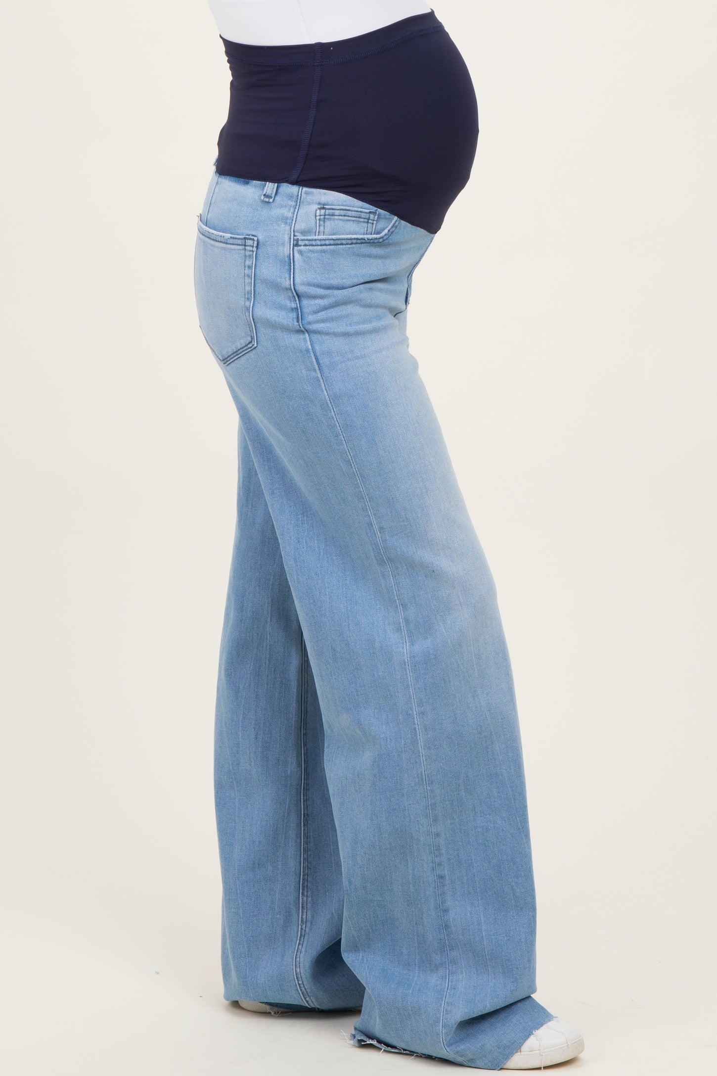 woman wearing light blue maternity wide-leg jeans with a supportive belly panel and visible baby bump