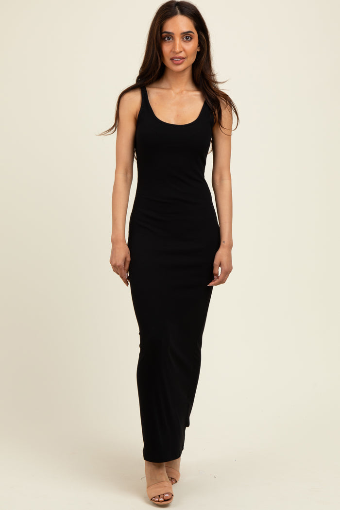 woman wearing a fitted black ribbed maxi dress with a scoop neckline and side slit