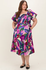 woman wearing a colorful floral print maternity dress with ruffled sleeves and pockets, showcasing a baby bump