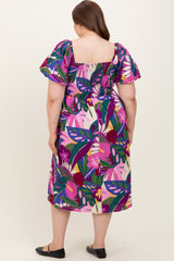 woman wearing a vibrant floral print maternity dress with puff sleeves, showing a back view