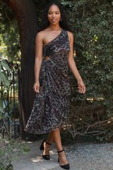 woman wearing a brown leopard print one-shoulder dress with a side cutout and draped detail, walking outdoors