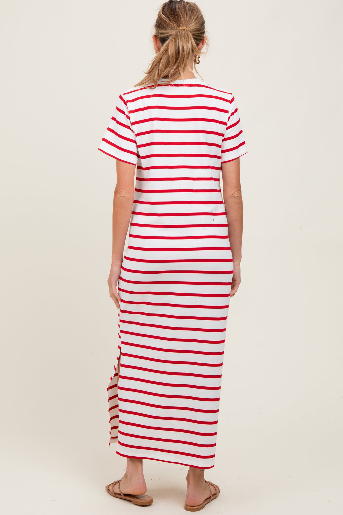 woman wearing a red and white striped maternity maxi dress with short sleeves and side slits
