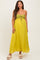 woman wearing a yellow maternity maxi dress with a crocheted bodice and tie detail, showing her baby bump