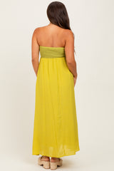 woman wearing a yellow strapless maternity maxi dress with a smocked bodice and a flowing skirt
