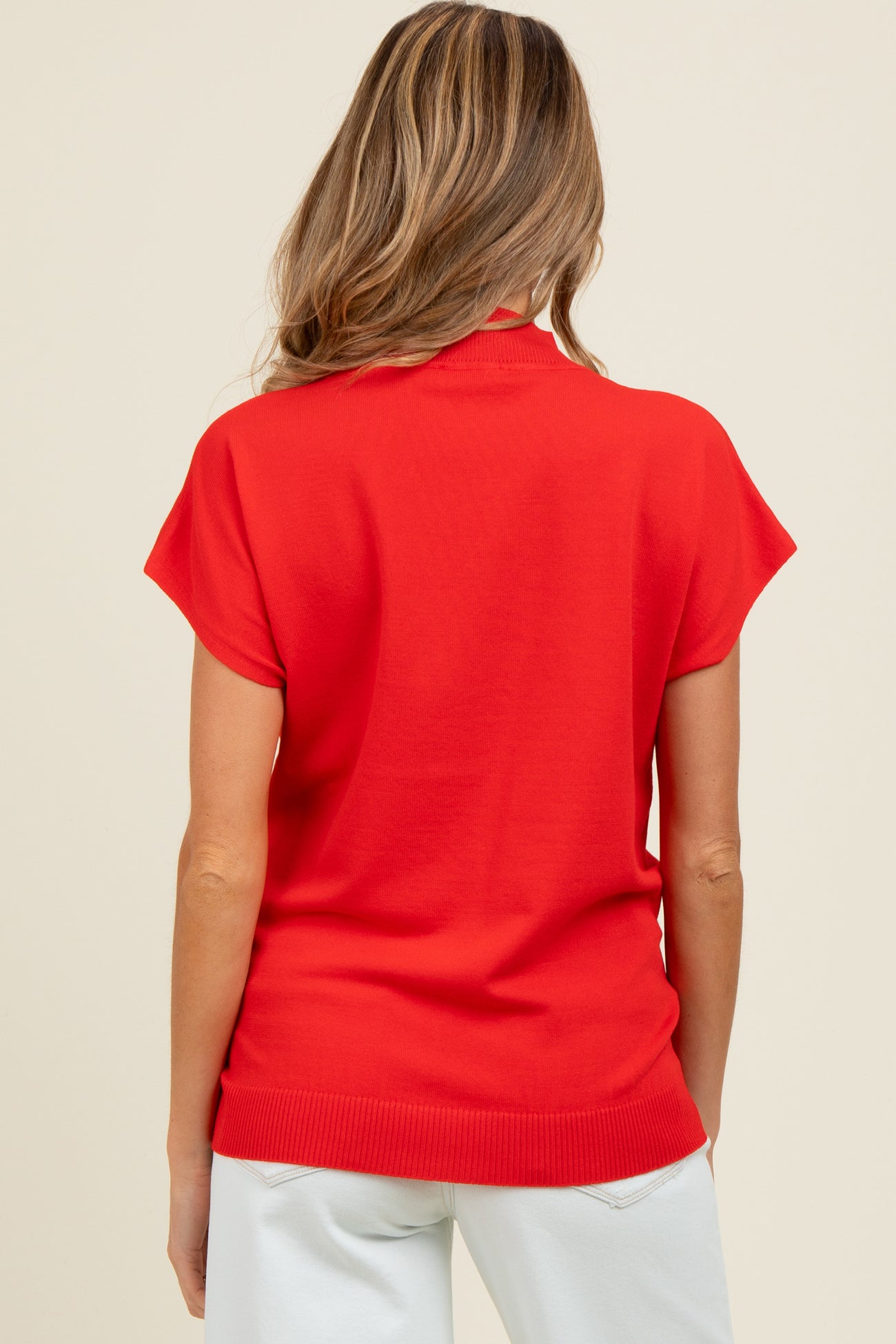 woman wearing a vibrant red short sleeve maternity top, viewed from the back