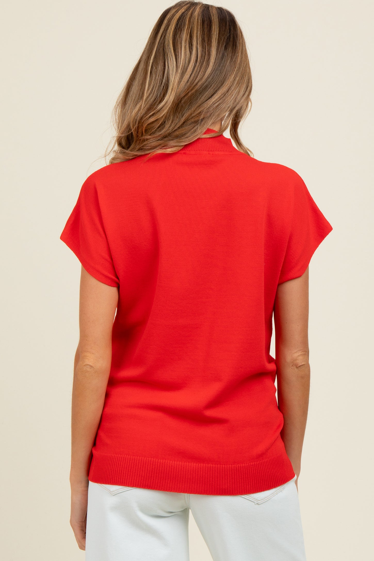 woman wearing a vibrant red short sleeve maternity top, viewed from the back