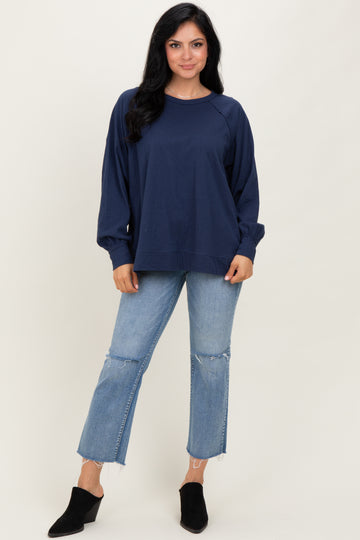 woman wearing a navy blue oversized sweatshirt with long sleeves and light blue distressed jeans