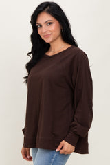 woman wearing a dark brown long sleeve oversized top with a relaxed fit and round neckline