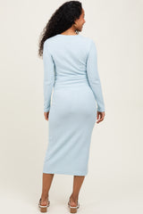 woman wearing a light blue ribbed maternity dress with long sleeves, showing off her baby bump from the back