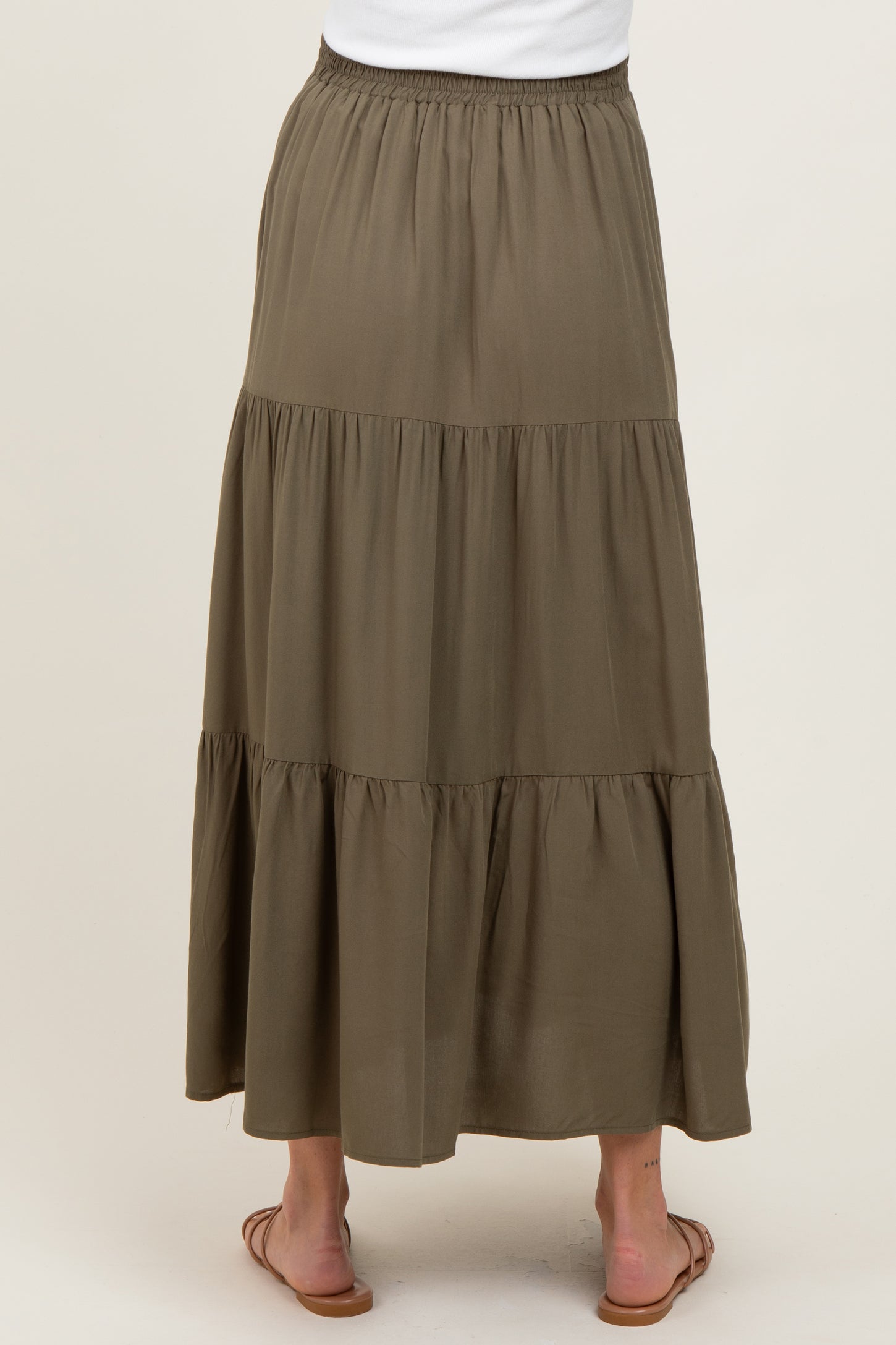 woman wearing a long olive green tiered maternity maxi skirt with an elastic waistband