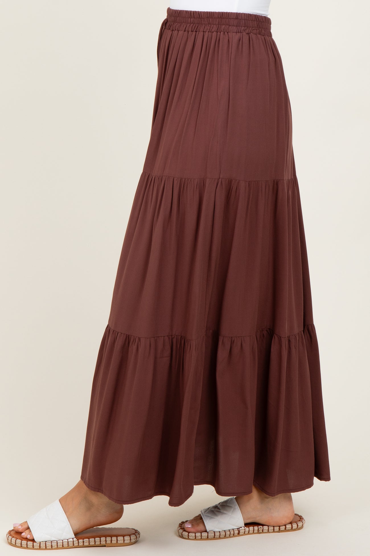 woman wearing a brown tiered maxi skirt with an elastic waistband and flat sandals