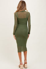 woman wearing an olive green long sleeve maternity dress with a form-fitting silhouette and midi length, showing her baby bump