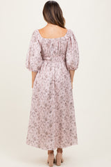 woman wearing a pink floral maternity dress with a cinched waist and puff sleeves, showcasing a baby bump from the back