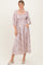 woman wearing a pink floral midi dress with puff sleeves and side pockets
