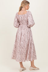 woman wearing a pink floral maxi dress with puff sleeves and a smocked back, standing sideways