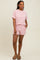 woman wearing a pink and white striped short sleeve top and matching shorts with pockets